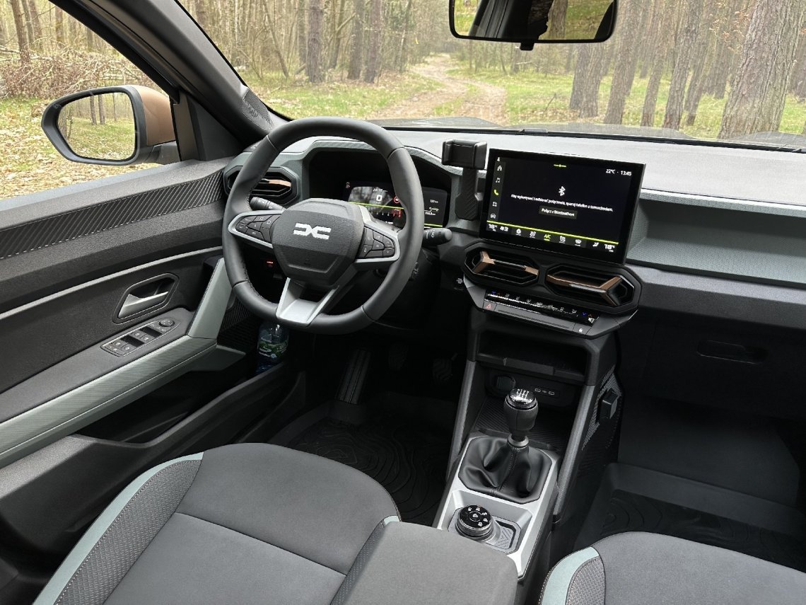 Z Dustera Bigster przejął także całe wnętrze. Jest uporządkowane i funkcjonalne. Ma ładowarkę indukcyjną, schowki, duży ekran, ukryty uchwyt na telefon czy ekran przed kierowcą w rozmiarze S lub XL (w zależności od wersji). Niestety wykonane jest też z tych samych materiałów.