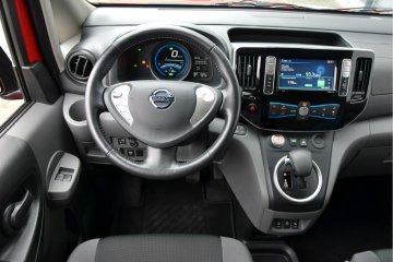 Elektryczny Nissan to typowy dostawczak, wykończony twardymi, szarymi tworzywami, oferujący jednocześnie sporą liczbę schowków.